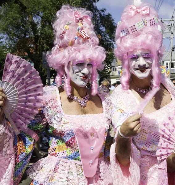 Drag queens in pink wigs walking in the Provincetown Carnival Parade in Provincetown, Massachusetts.