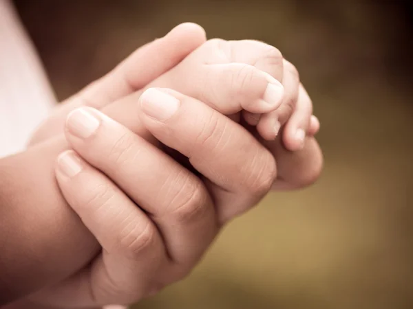 Closeup of mother and baby\'s hands with retro effect