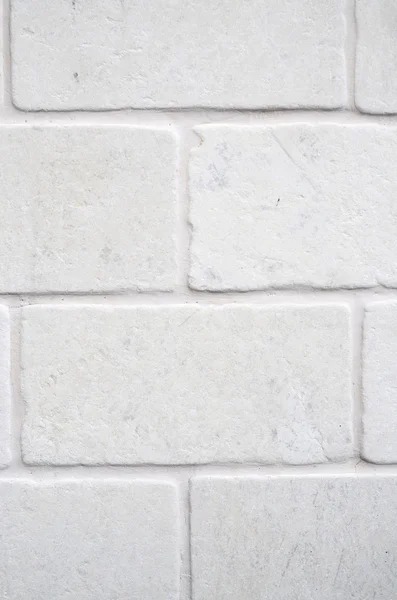 Decorative white cladding slabs imitating stones on wall