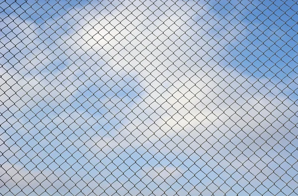 Fence metallic net and cloudy sky