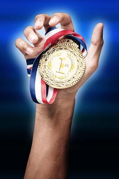 Hand holding up a gold trophy