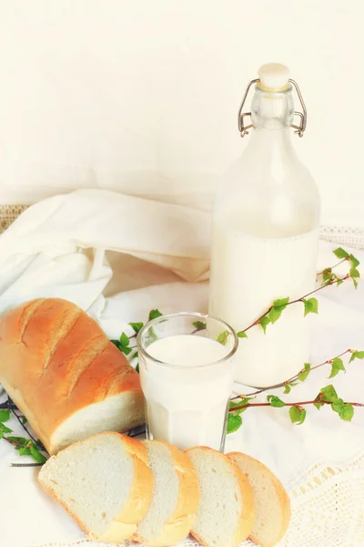 Milk and bread on a white lace background bio organic product fresh pastries healthy lifestyle