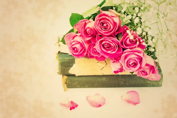 Bouquet of pink roses on old books floral background is love tenderness vintage retro selective soft focus