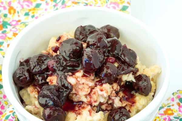 Breakfast oatmeal with cherry jam in a white ceramic bowl shabby chic retro vintage health diet selective soft focus