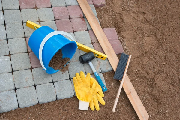 Stone blocks rubber hammer level gloves and tape measure