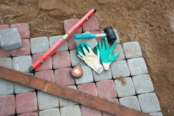 Stone blocks rubber hammer level gloves and tape measure