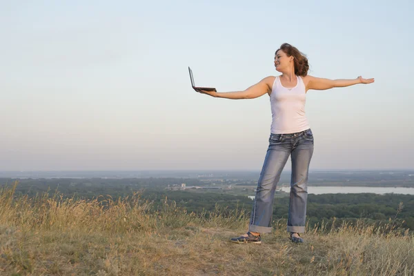 Girl with a computer on nature