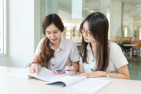 Two Asian students studying together at university