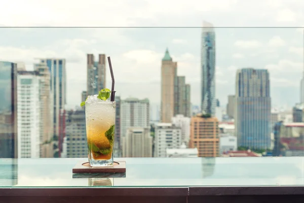 Mojito cocktail on table in rooftop bar with Bangkok city view p