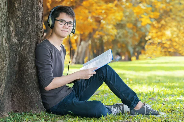 Handsome student listening music in the park