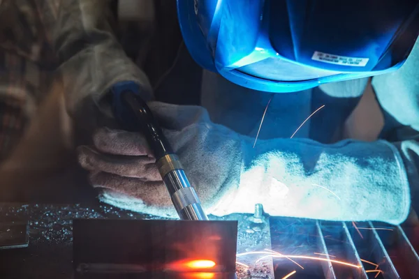 Close up of worker with protective mask welding metal.Selective