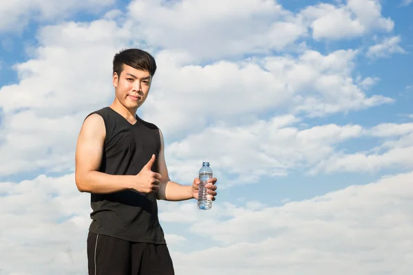 Asian fitness man holding water bottle and giving thumb up again