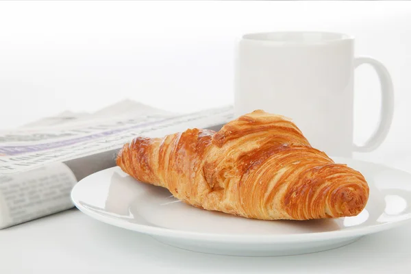 Cup of black coffee, croissants and newspaper