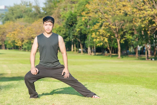 Asian fitness man stretching at the park - fitness concepts spor