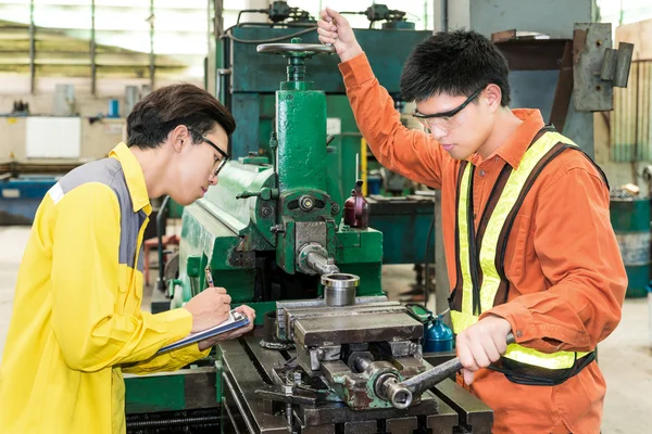 Asian Mechanical Engineer checking equipment in factory