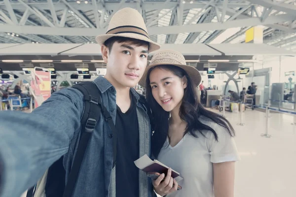Asian couple tourist taking a selfie in airport before journey