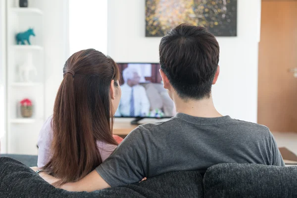 Young Asian couple waching movie on tv at home