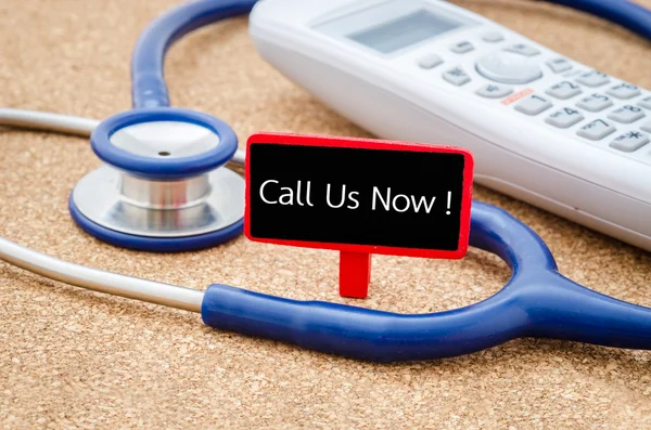 Phone and stethoscope on the table with Call Us Now words.