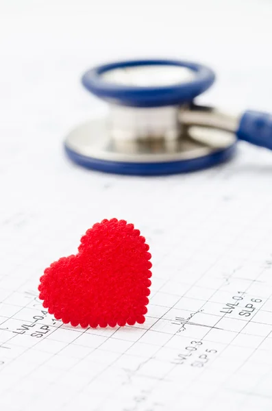 Cardiogram chart with medical stethoscope and small red heart.