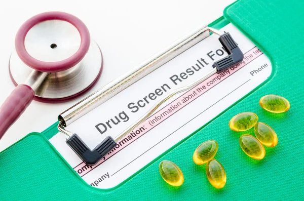 Drugs and drug screen result form in file with stethoscope.