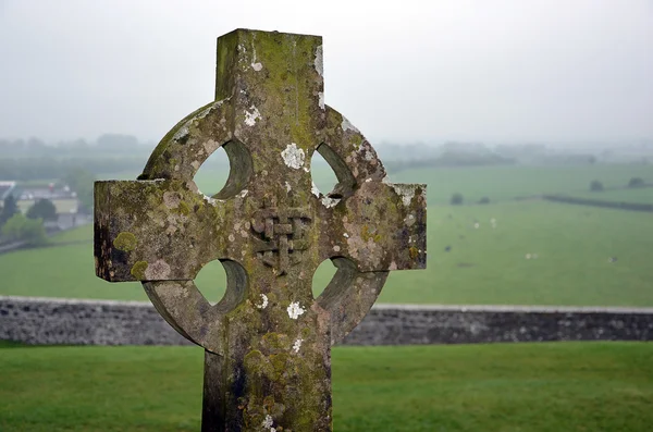 Celtic cross on the graveyard and nature landscape