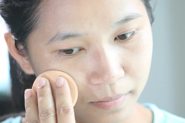 Woman applying make up.