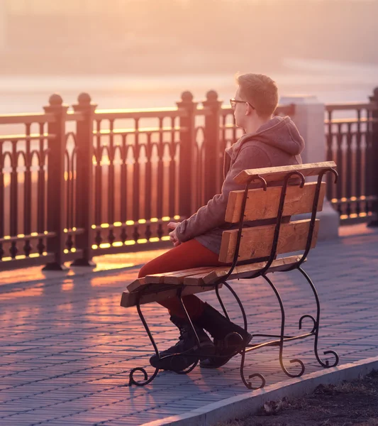 Lonely Man Sitting on a Bench during Sunset. Young Man Sitting o