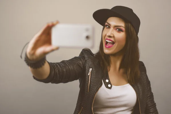 Young trendy woman with snapback-Cap and black leather jacket