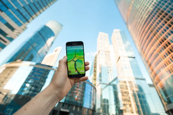 Russia, Moscow - August 24: 2016 Smartphone with Pokemon Go application. On the background of skyscrapers. Augmented reality mobile game developed by Niantic for phone