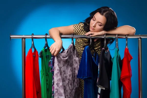Sad Woman Under The Clothing Rack With Dresses