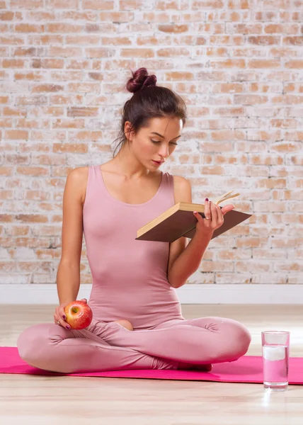 Beautiful Girl Doing Yoga Exercises And Read Book