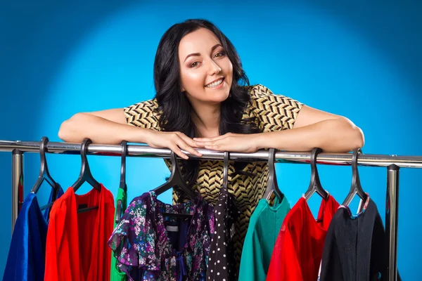 Happy Woman Over The Clothing Rack With Dresses