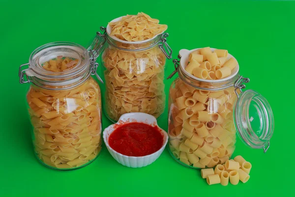 Three jars of pasta with red sauce bowl