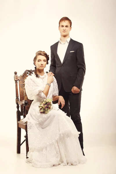 Portrait of young man and woman on vintage chair retro wedding