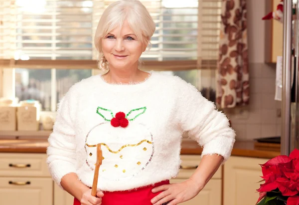 Pretty grandmother in kitchen, christmas time.