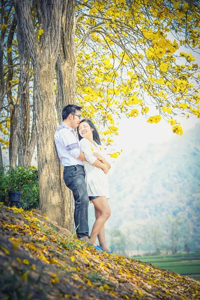 Asia happy couple standing under tree