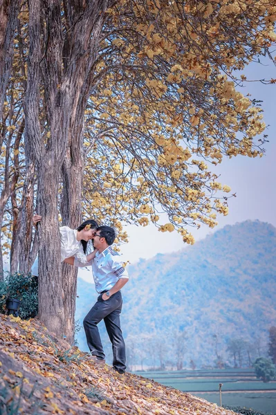 Asia happy couple standing under tree