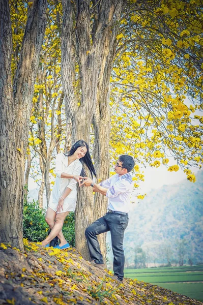 Asia happy couple standing under tree