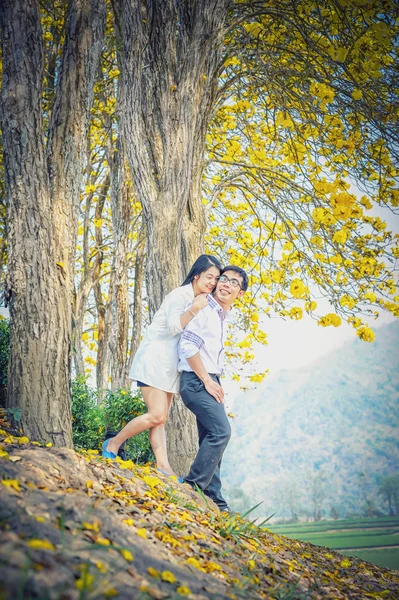 Asia happy couple standing under tree