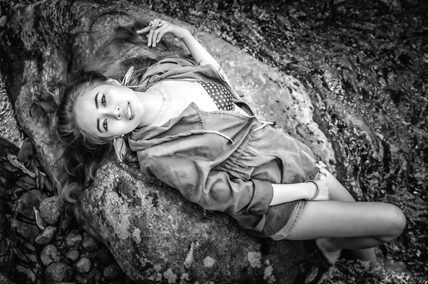 Asia beautiful young sexy girl lying down on a rock