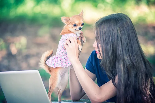 Young happy woman with her dog and laptop