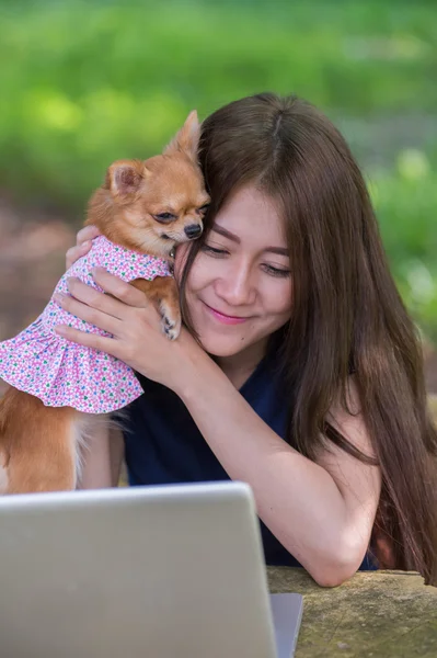 Young happy woman with her dog and laptop