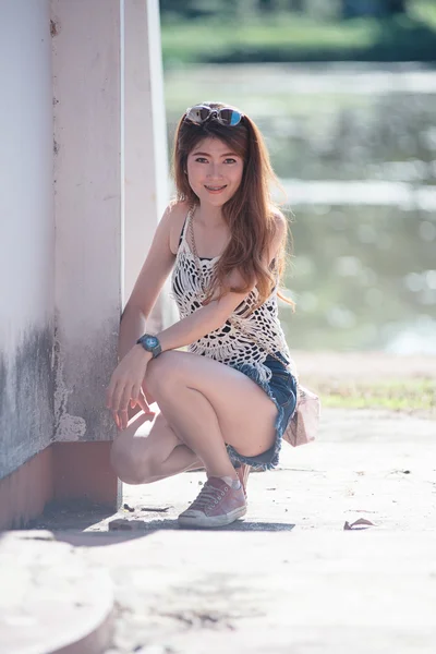 Woman sitting down on old stone wall