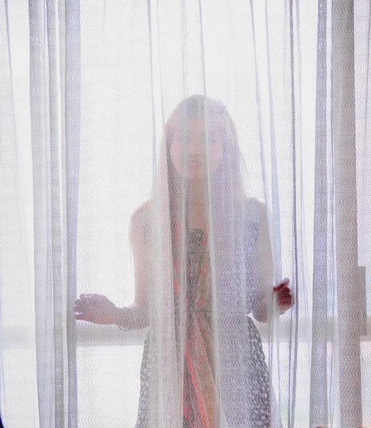 Asia young woman behind the curtains