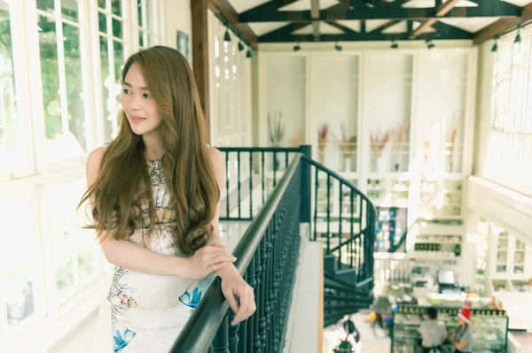 Beautiful asia young woman stand at balcony in cafe