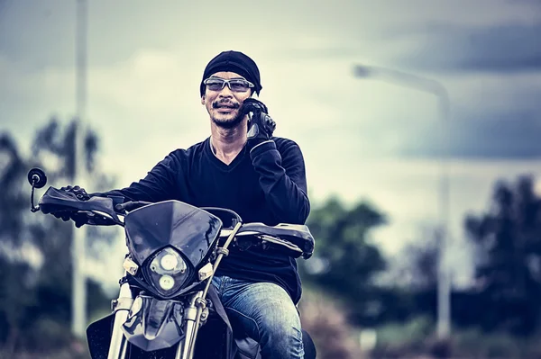 Asia handsome man biker call telephone on the motorcycle