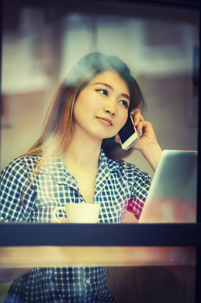 Asia woman talking  phone in cafe and enjoying coffee