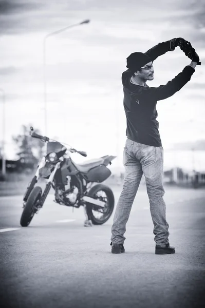 Biker relax with motorbike on sunset.