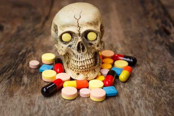 Human skull in the pile of drugs.