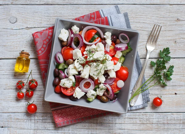 Greek salad with tomatoes, feta cheese, cucumbers, onions and olives